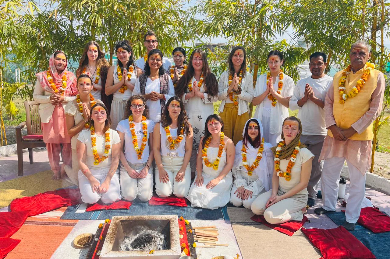 Students and teachers in namaste after a havan ceremony